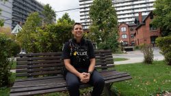 Portrait of Constable Cory McAree sitting on a bench in Minto Park in Ottawa.