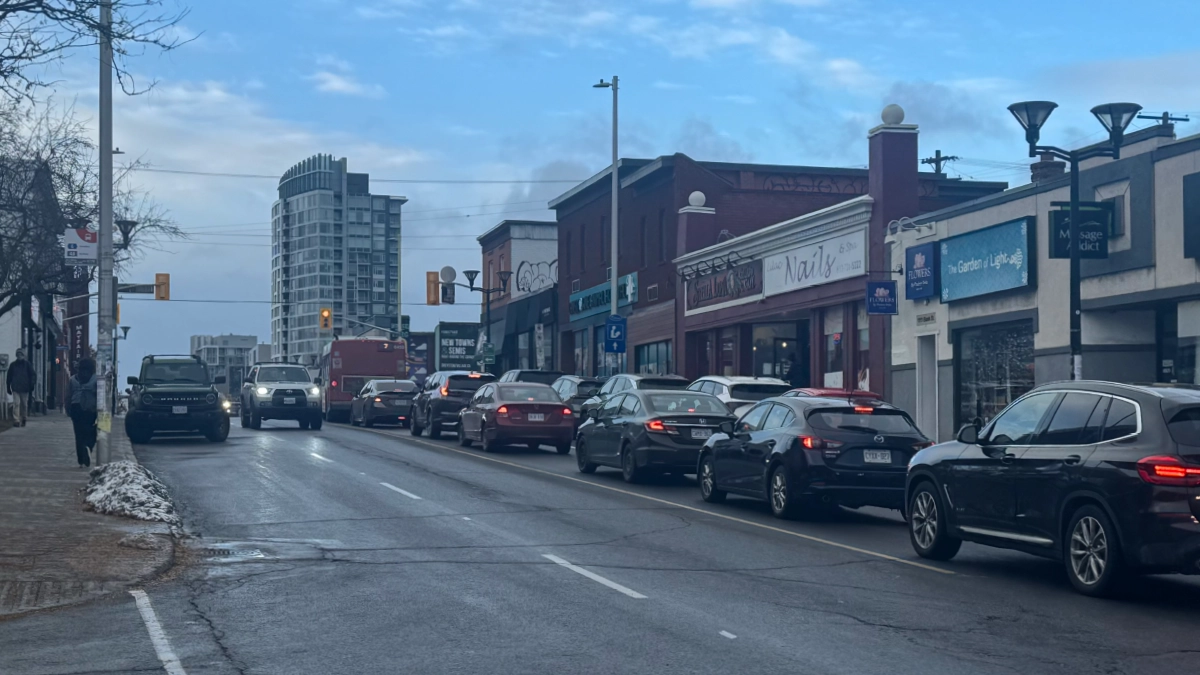 The Route 7 Lansdowne (northbound) pulls over to board and disembark commuters along Bank Street on Sunday, Nov. 16, 2025 at 3:23 P.M. A long line of cars gathers behind the bus as a result.  